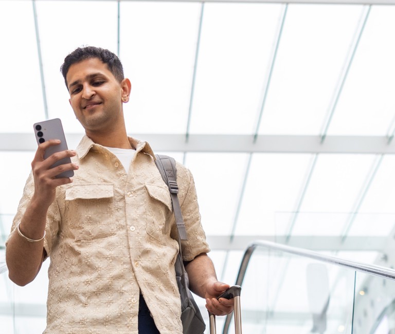 Person with suitcase checking mobile phone