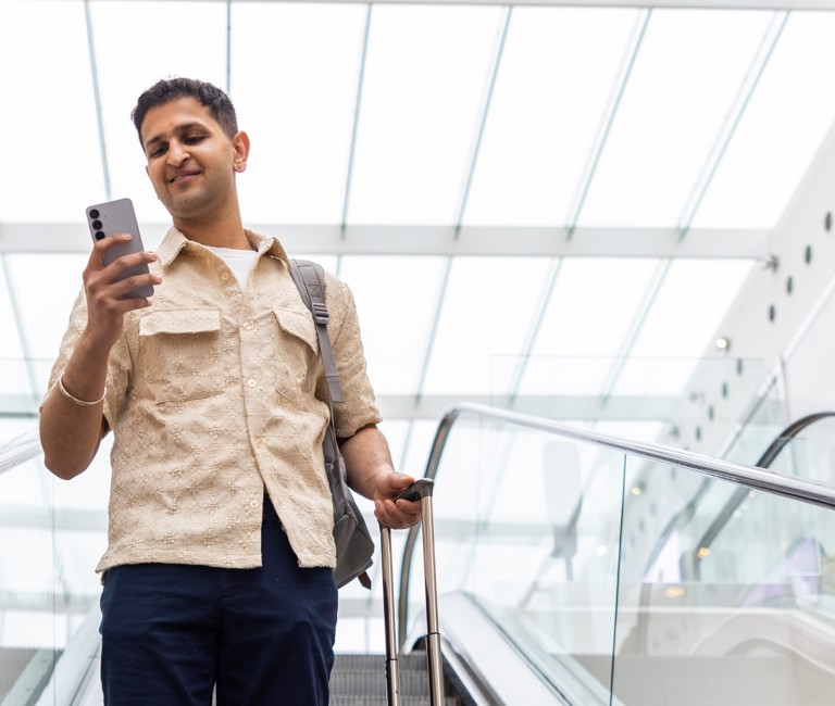 Man checking phone in airport